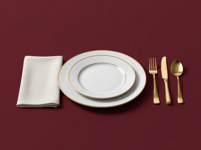 Soft-lit 3D render of a porcelain place setting, linen napkin and brass cutlery on a plain burgundy background
